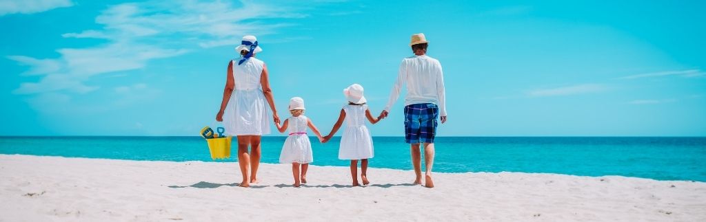Familien in Thailand genießen einen Tag am Strand unter tropischem Himmel