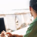 Chiang Mai digital nomad working on a laptop with a view of the beach and ocean