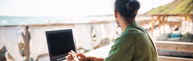Chiang Mai digital nomad working on a laptop with a view of the beach and ocean