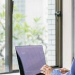 Nomade numérique à Chiang Mai travaillant sur un ordinateur portable avec vue sur l'extérieur.