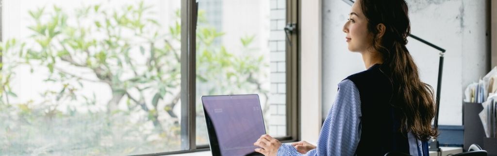 Nomade numérique à Chiang Mai travaillant sur un ordinateur portable avec vue sur l'extérieur.