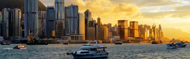 Vue du front de mer et des gratte-ciel au coucher du soleil illustrant la fiscalité Hong Kong et l’environnement économique du territoire
