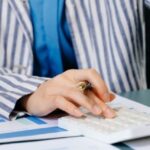 Professionals reviewing financial statements with calculator and reports in Thailand office