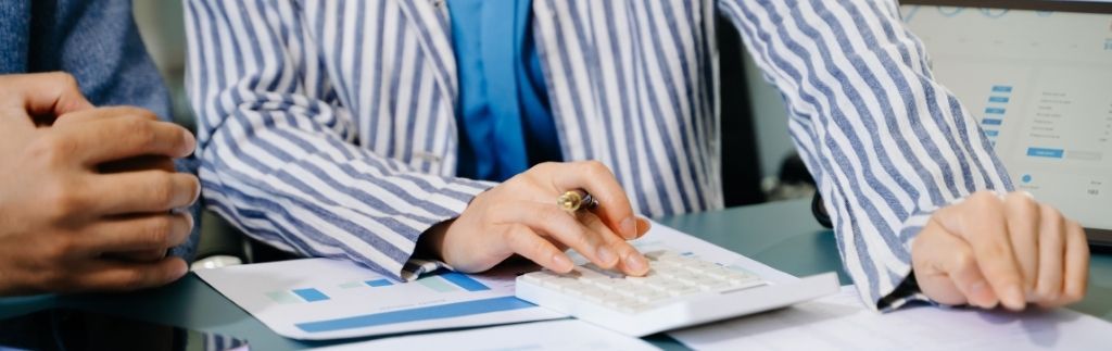 Professionals reviewing financial statements with calculator and reports in Thailand office