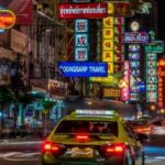 Thailand traffic rules illustrated by busy night traffic in Bangkok Chinatown with taxis, motorbikes, and dense urban road conditions