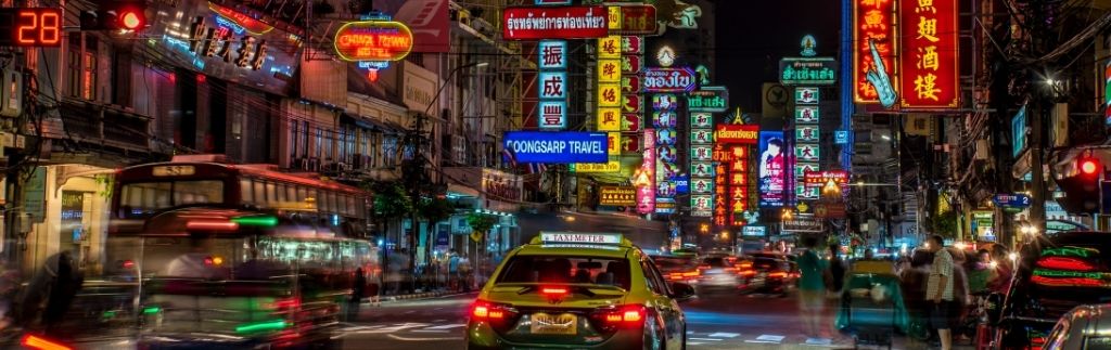 Thailand traffic rules illustrated by busy night traffic in Bangkok Chinatown with taxis, motorbikes, and dense urban road conditions