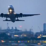 Avion décolle au coucher du soleil avec une ligne d'horizon de la ville, symbolisant l'impact des tensions géopolitiques sur le trafic aérien. Est-il dangereux d’aller en Thaïlande en ce moment ?