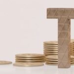 Tax concept with stacked coins and letters spelling 'TAX', representing dividend taxation in Thailand.