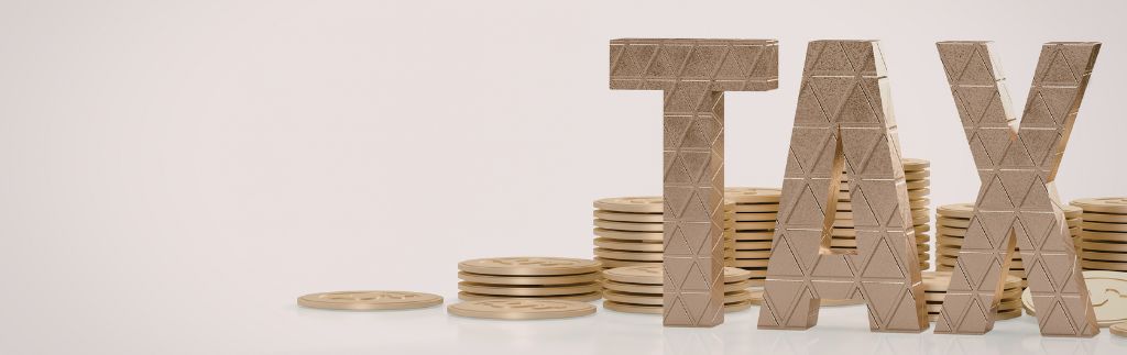 Tax concept with stacked coins and letters spelling 'TAX', representing dividend taxation in Thailand.