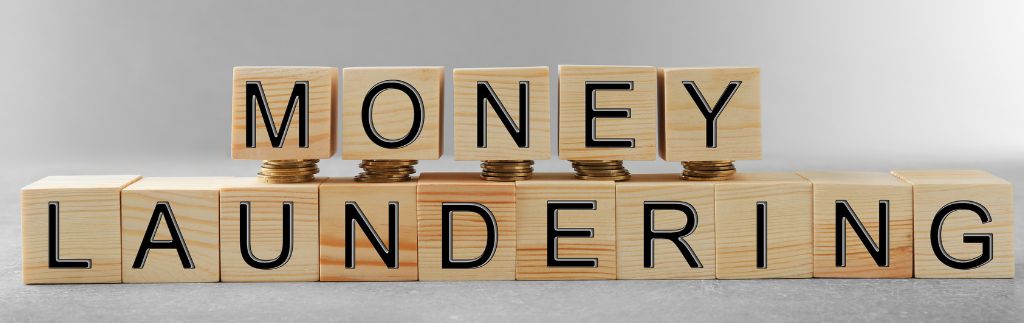 Wooden blocks spelling "MONEY LAUNDERING" with a focus on the importance of Anti Money Laundering in Thailand to prevent illicit financial activities.