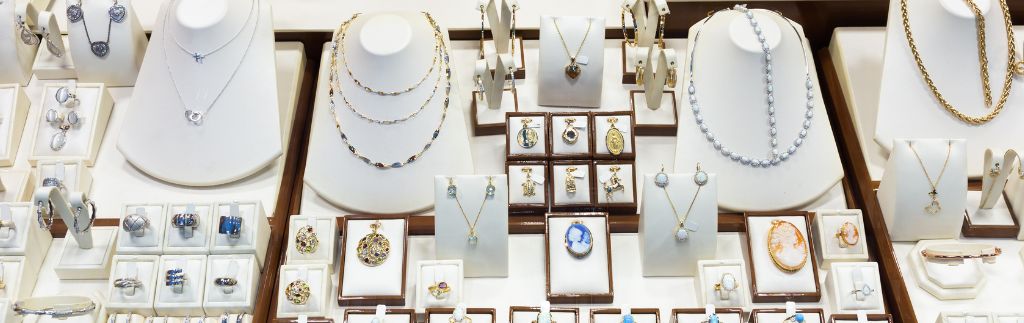 Présentation élégante de colliers, bagues, bracelets et pendentifs exposés dans une vitrine de commerce bijoux en Thaïlande.