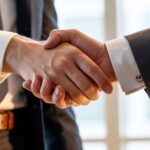 Poignée de main entre deux hommes d'affaires illustrant un accord de prête-noms en Thaïlande