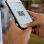 Person scanning a QR code payment in a restaurant in Thailand
