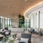 Hotel Thailandia – elegante lobby di hotel moderno con design raffinato, ampie vetrate e area relax luminosa.