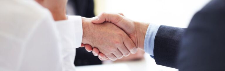 Two professionals shaking hands — legal advice on BOI and the Treaty of Amity to invest in Thailand
