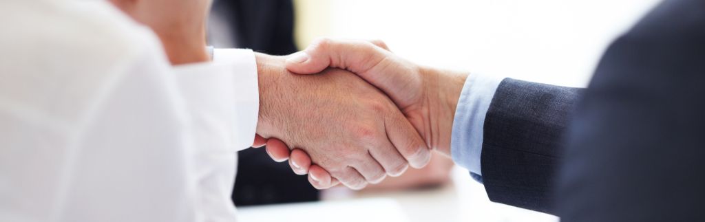 Two professionals shaking hands — legal advice on BOI and the Treaty of Amity to invest in Thailand