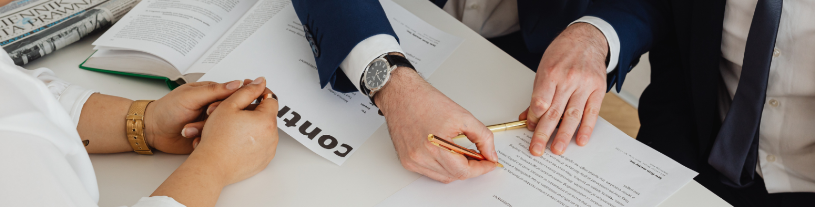Business professionals reviewing and signing a business agreement contract during a meeting