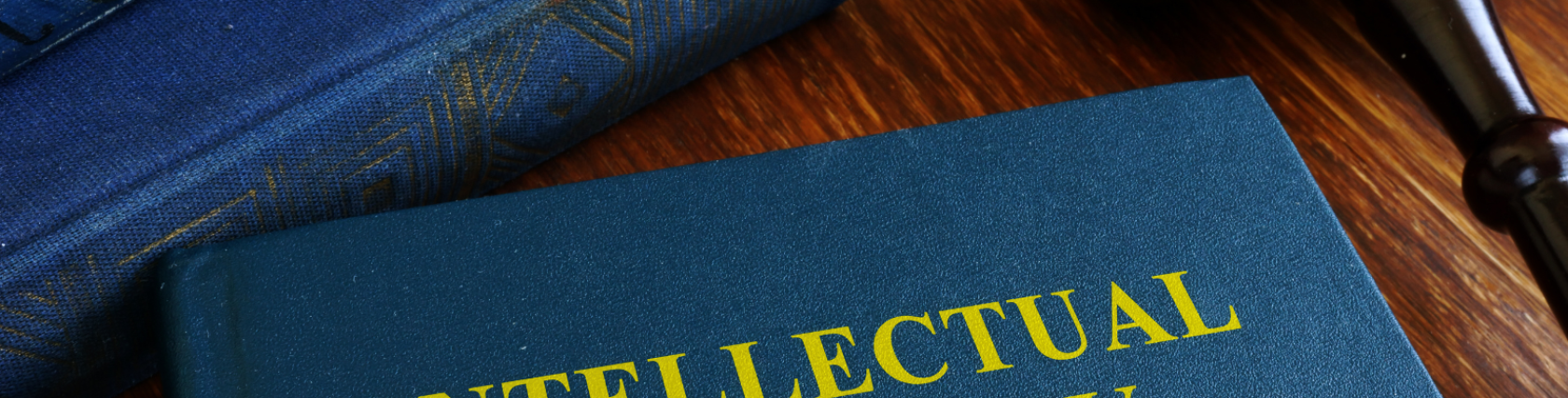 Intellectual property law book with legal gavel on a wooden desk